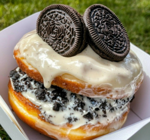 Oreo Cheesecake Stuffed Donut Burger with creamy filling and Oreo glaze served on a white plate