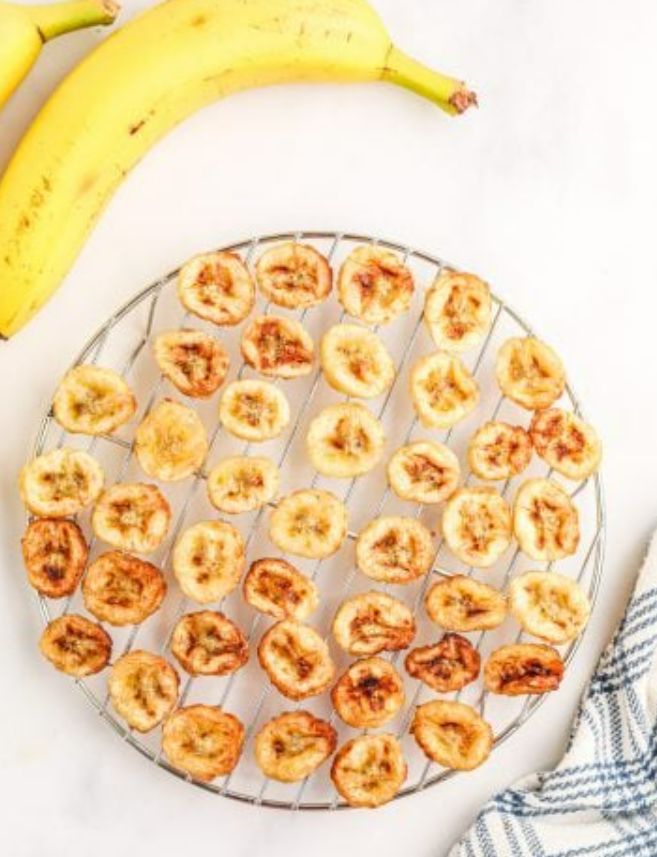 Banana slices coated with cinnamon mixture for homemade banana chips preparation