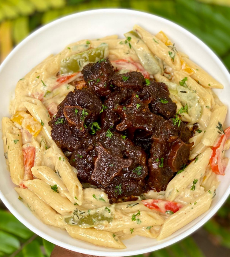 Elegant plated slow-braised oxtail pasta in white bowl with wine glass and crusty bread